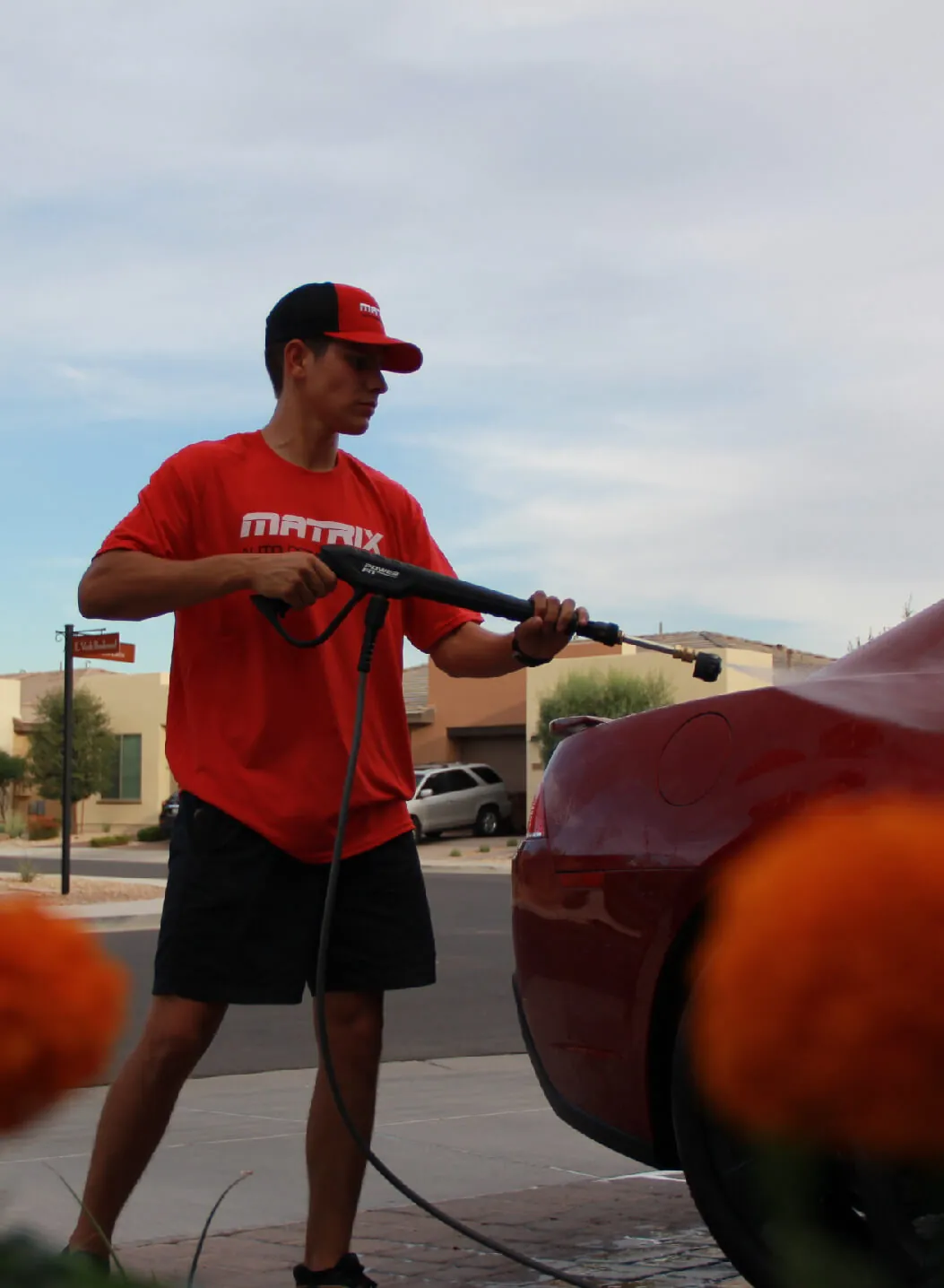 Braiden Lara, founder of Matrix, pressure washing a red car