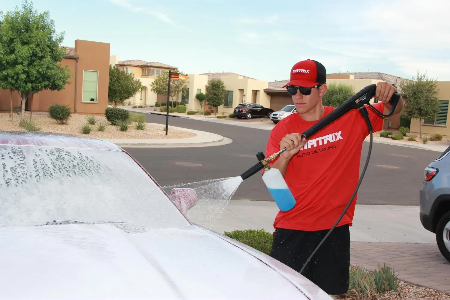 A Matrix technician foaming a car in a driveway