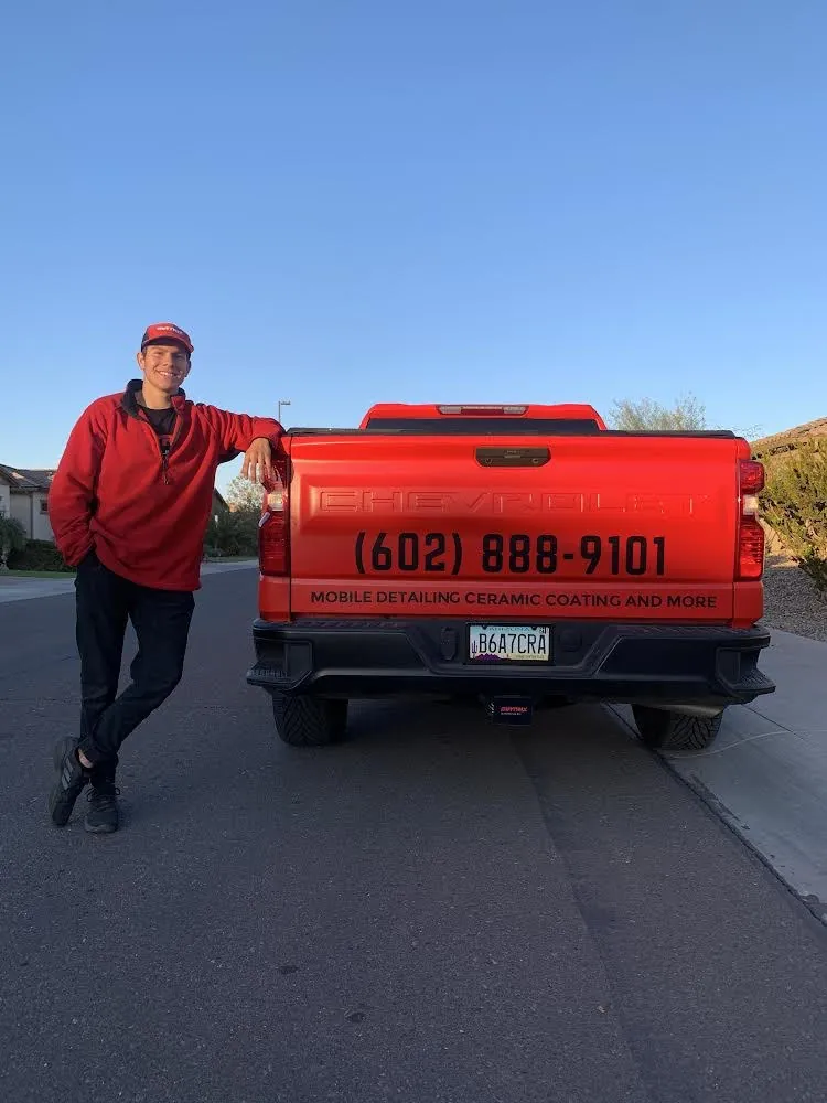 Braiden leaning on the red Matrix truck